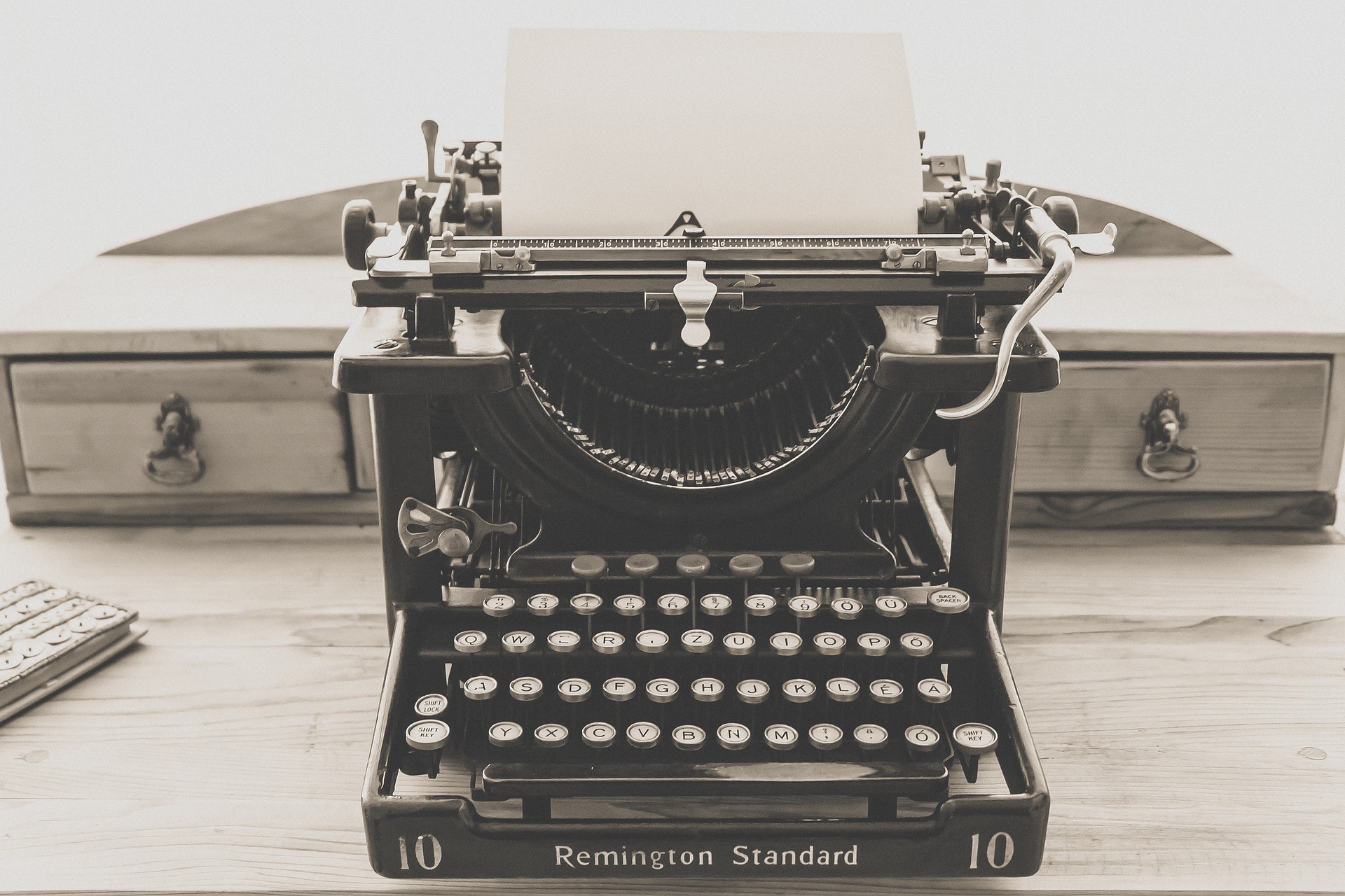 Old Remington typewriter with blank piece of paper in it, waiting for your eager fingers to start typing.
